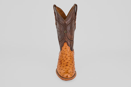 The Austin - Brandy - Roper Toe is a men's cowboy boot featuring a brown leather upper and light tan textured ostrich leather lower, shown upright on a plain white background. Ideal for fans of classic ostrich leather boots.