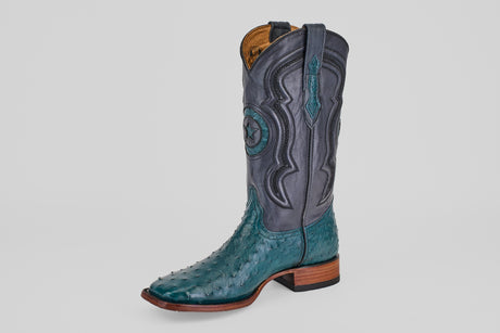 The Austin - Gasoline Green - Square Toe is a men's western boot with a teal ostrich leather foot, dark gray shaft with decorative stitching and star design, wooden heel, and pull straps.