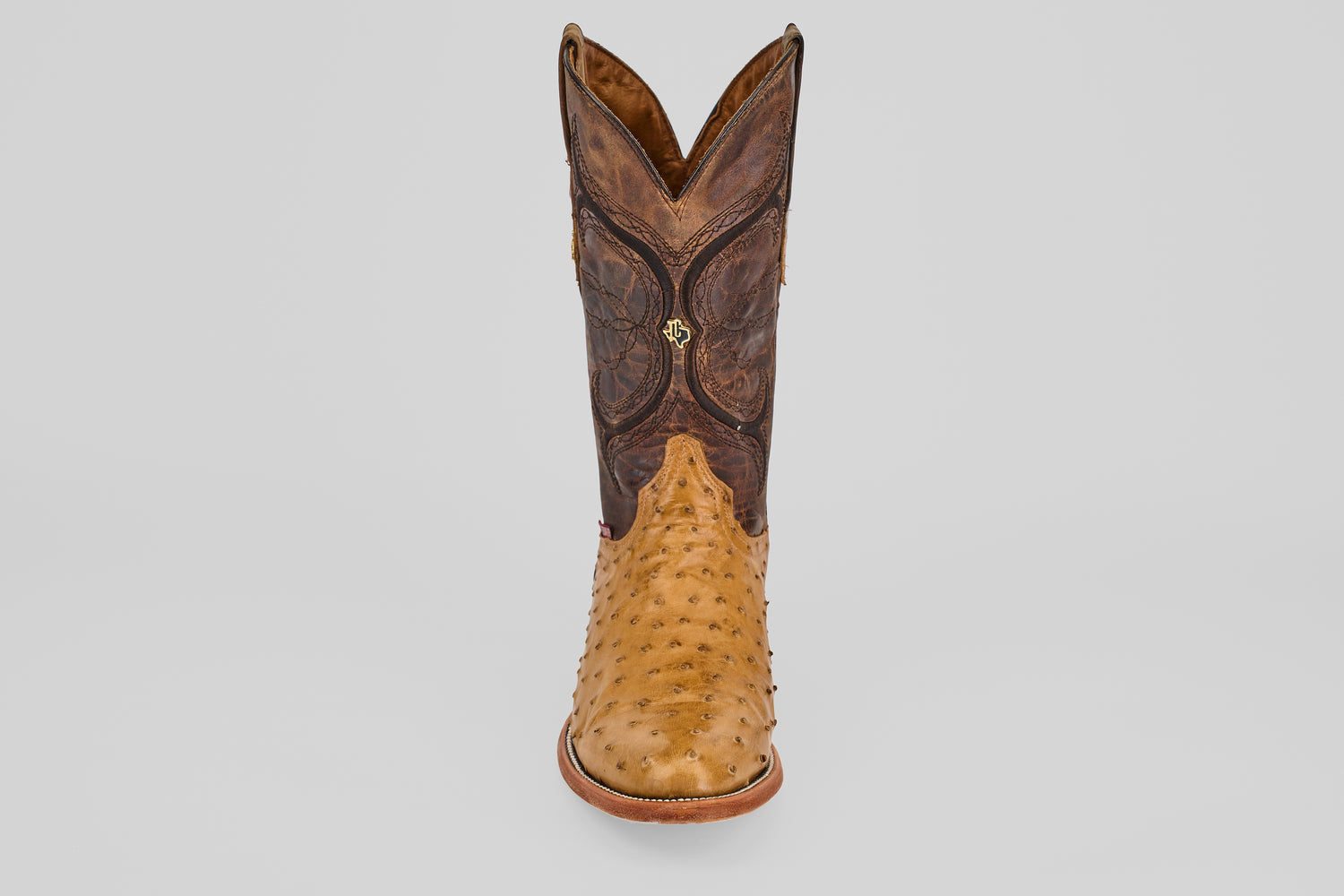 The Austin - Antique - Roper Toe cowboy boot features a light tan, textured lower section and a dark brown, decorative upper shaft, displayed from the front against a plain white background.