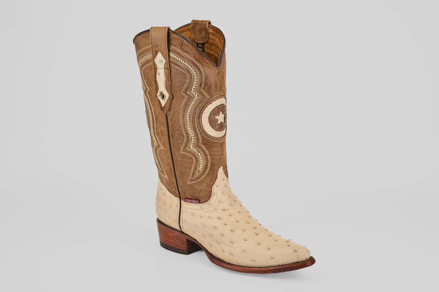 The Austin - Bone - Snip Toe is a western boot featuring a tan ostrich leather foot, light brown shaft with stitched patterns, pull straps, a wooden heel, and snip toe—ideal for ostrich leather cowboy boot enthusiasts.