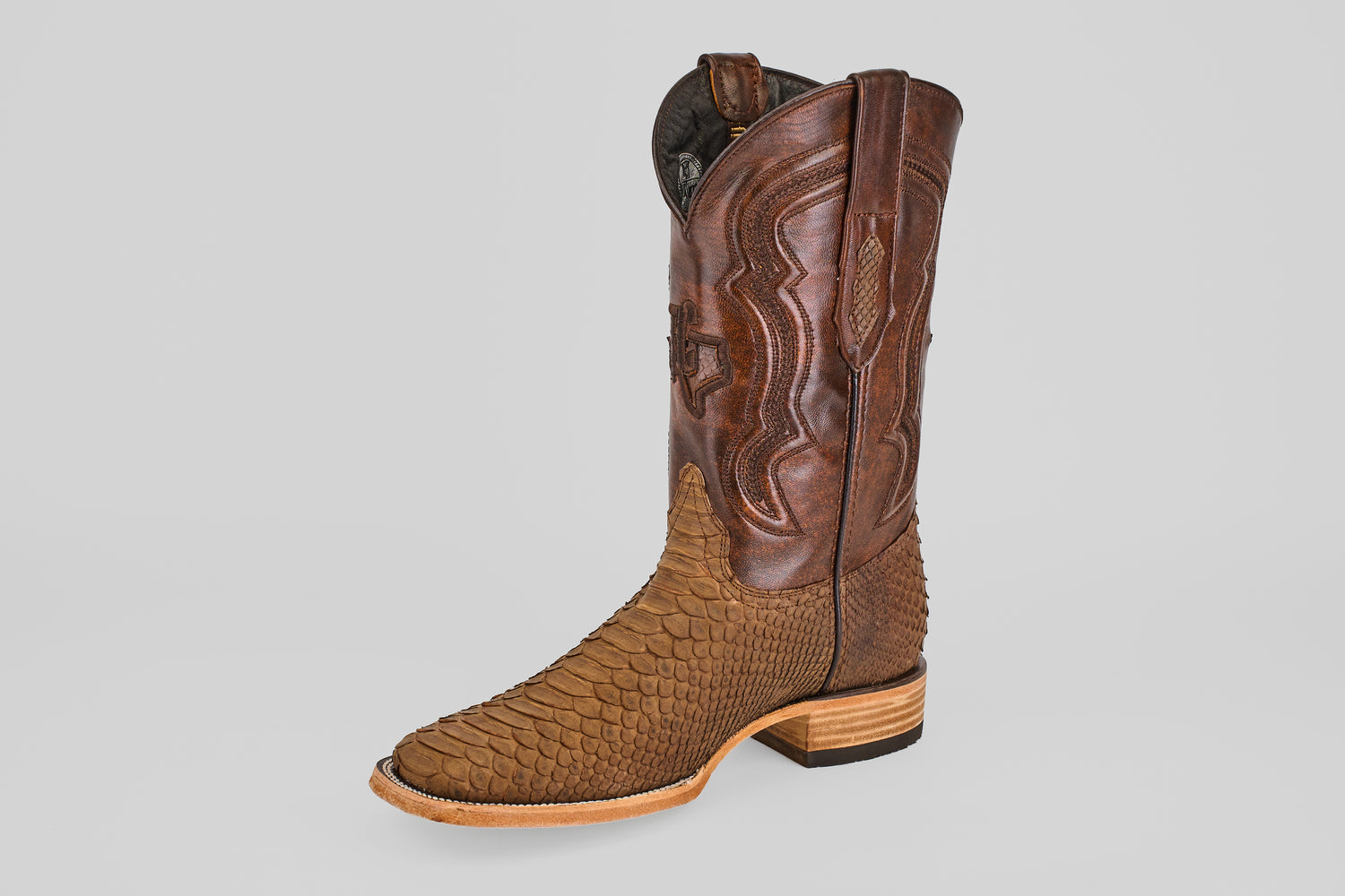 The Tanner - Tamarindo - Square Toe cowboy boot is brown with a textured, scaly lower section, a smooth, stitched upper shaft, and a low wooden heel, shown against a plain light gray background.