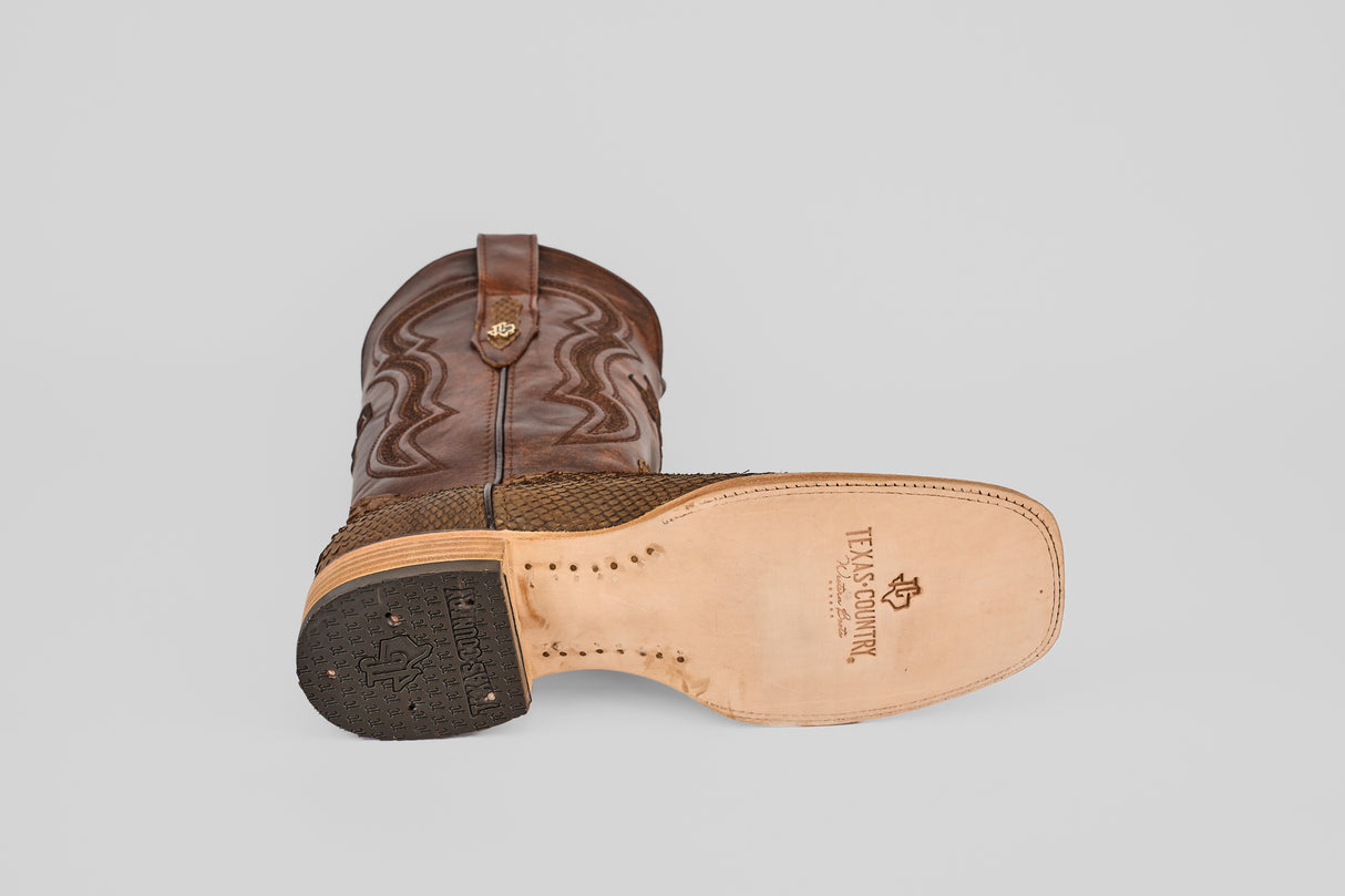 The Tanner - Tamarindo - Square Toe boot is shown from the top, highlighting its textured Python Tamarindo upper with stitching, and from the bottom, displaying a leather sole stamped with the Texas Country logo and a patterned black heel.