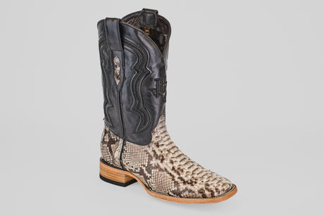The Tanner - Natural - Square Toe cowboy boot features a tan and brown Python Natural (PN30) snakeskin-patterned lower, black leather upper with decorative stitching, and a wooden heel paired with a black rubber sole.