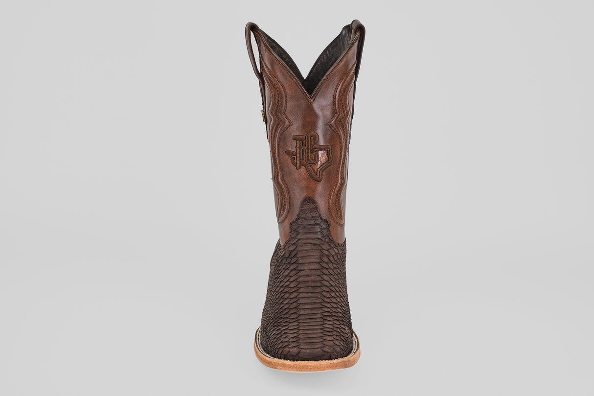 A single Tanner - Matte Brown - Square Toe cowboy boot, featuring a textured Python Cafe Nobuck foot, smooth leather shaft with decorative stitching, and tan sole, is shown from the front against a plain light background.