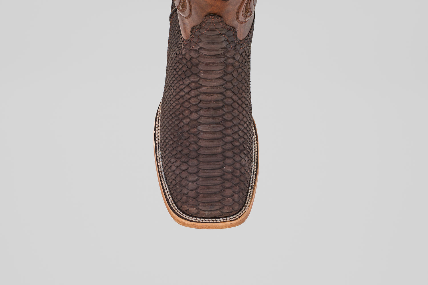 A close-up top view of the Tanner - Matte Brown - Square Toe cowboy boot, crafted in brown with a square toe and decorative stitching, set against a plain white background.