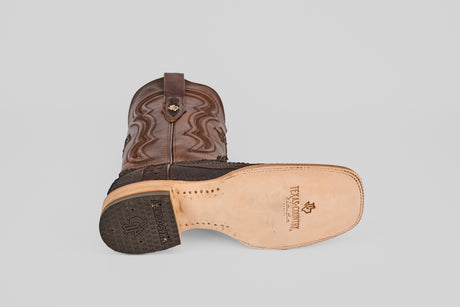 A Tanner - Matte Brown - Square Toe cowboy boot lies on its side, displaying the textured leather upper, light tan sole stamped with the Texas Country logo, square toe, decorative stitching, and model number 501-N.