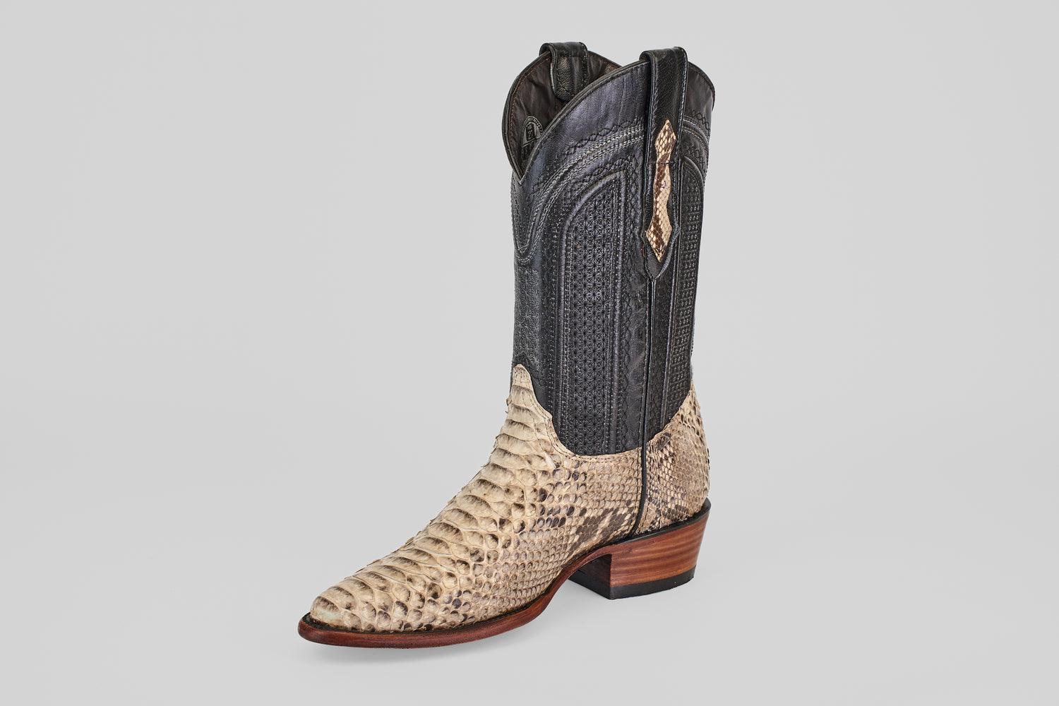 A single Tanner - Natural - Snip Toe cowboy boot, with a dark upper and light, snakeskin-textured lower, pointed toe, and low wooden heel, displayed against a plain light background.