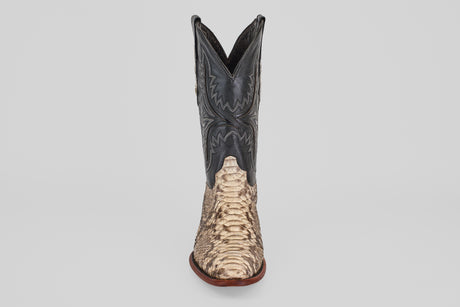 The Tanner - Natural - Roper Toe cowboy boot features a natural tan python snakeskin lower section and a black leather upper with detailed stitching, shown upright against a plain light background.