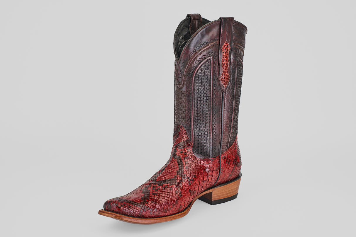 The Tanner – Ruby – Narrow Square Toe is a single western boot in red and brown snakeskin leather with decorative stitching, a pointed toe, and a low wooden heel, shown on a plain light background.