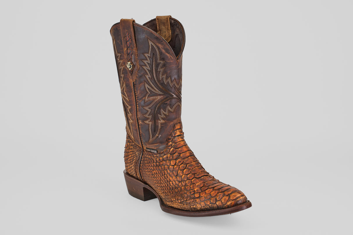The Tanner – Chestnut – Round Toe boot features a textured python leather pattern on the foot and heel, intricate shaft stitching, and a brown round toe design—ideal for western fashion fans. Set against a plain light gray background.