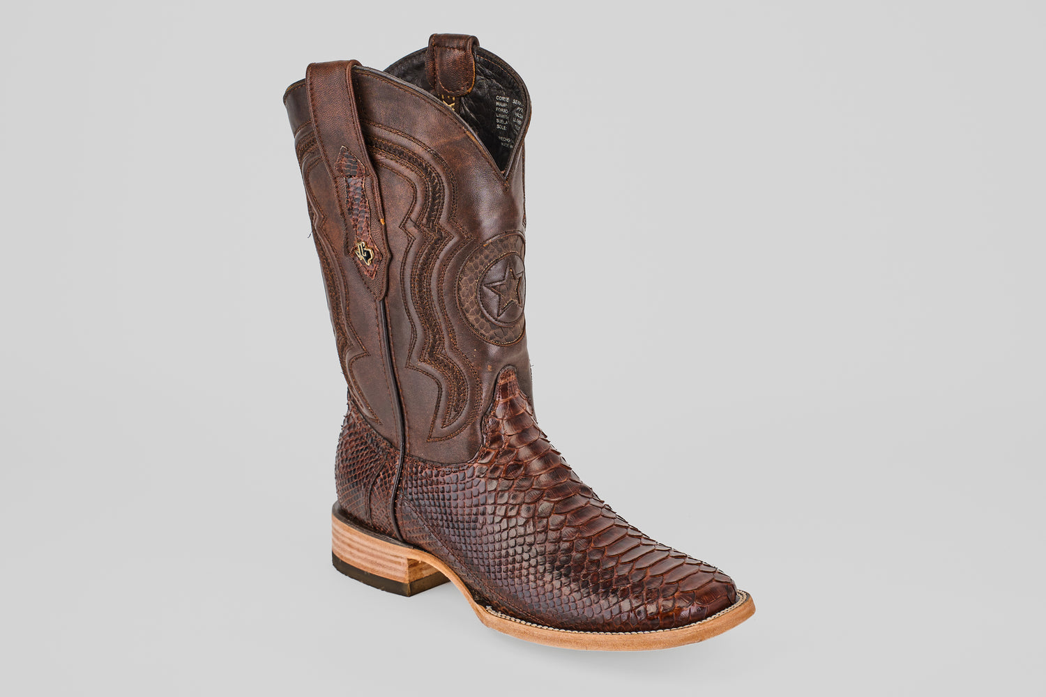 The Tanner - Brown - Square Toe cowboy boot features a textured snakeskin foot, decorative shaft stitching, star emblem, and light wooden heel, shown in a photo against a plain light gray background.