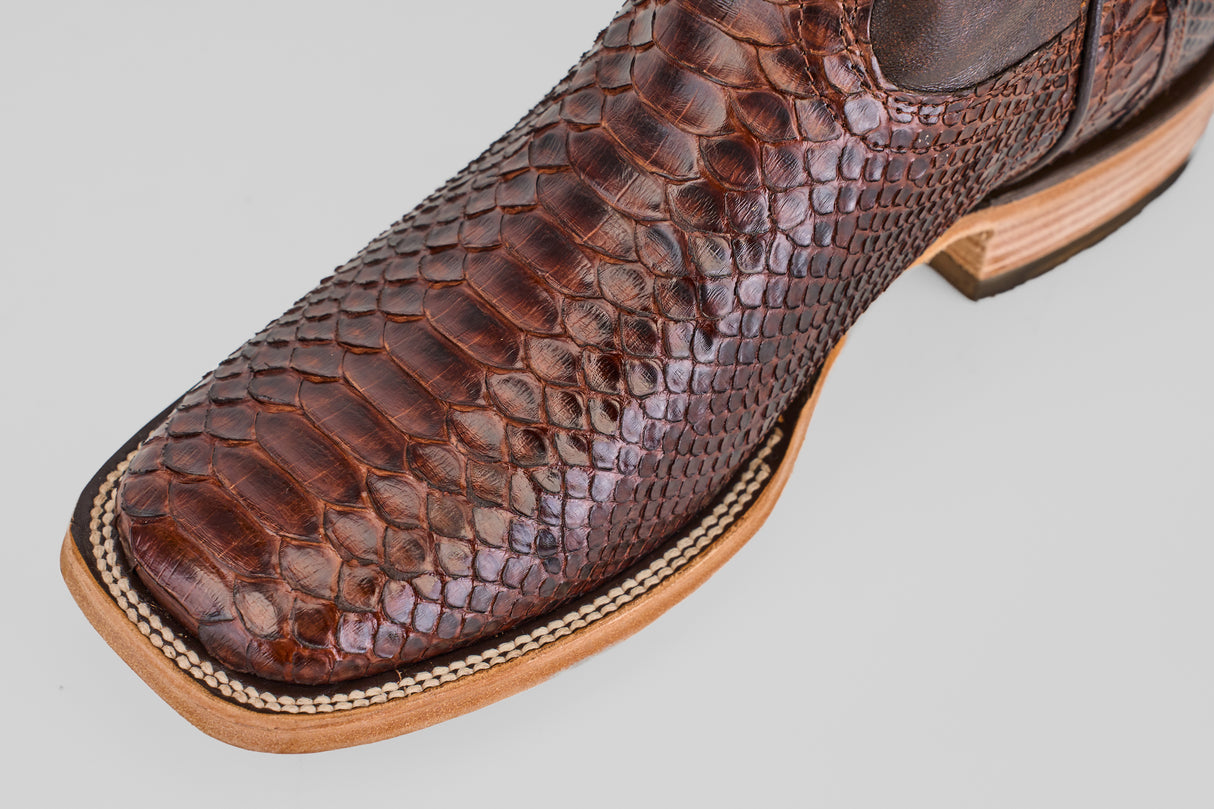 Close-up of the toe and side of the Tanner - Brown - Square Toe boot, showing its snakeskin texture, detailed stitching on the light-colored sole, and square toe design.