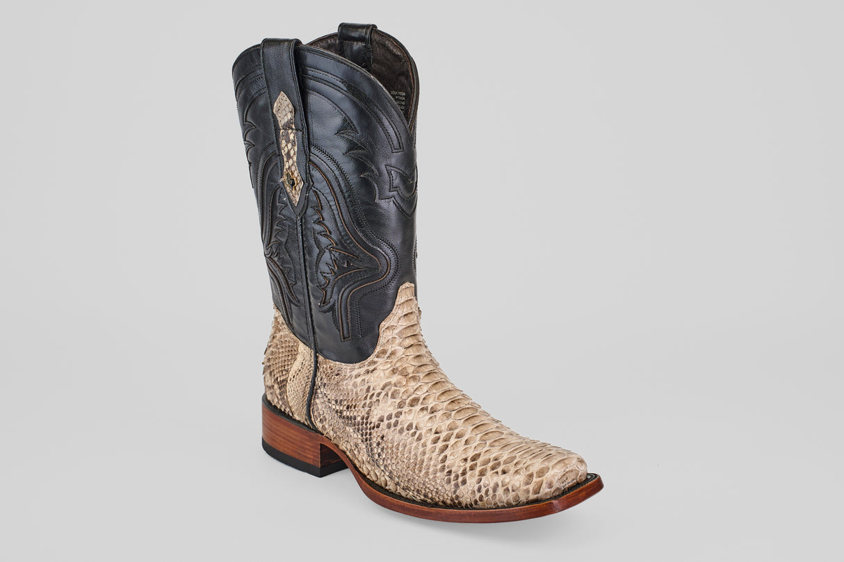 The Tanner - Natural - Rodeo Toe is a single cowboy boot featuring a light tan python snakeskin lower, black leather upper with detailed stitching, a square "Rodeo" toe, and wooden heel—ideal for any rodeo occasion.