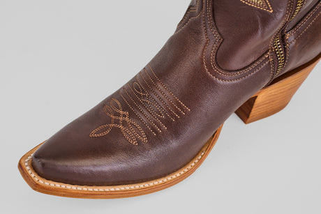 A close-up of the Allison Dark Moka - Tall Shaft - Snip Toe boot shows its decorative stitching, dark mocha leather, pointed toe, and light wooden heel—ideal for anyone seeking stylish women's cowboy boots.