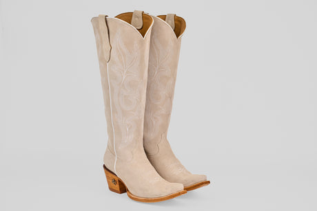 The Allison Ivory - Tall Shaft - Snip Toe women's western boots in light beige feature decorative stitching, pointed toes, and stacked wooden heels, showcased against a plain light background.