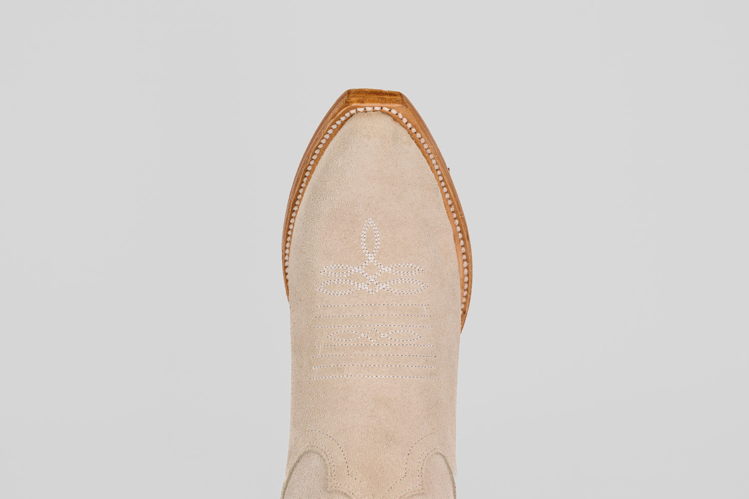 A top-down view of the Allison Ivory - Tall Shaft - Snip Toe boot highlights its ivory color, snip toe, white decorative stitching, and brown leather trim, exemplifying classic women's western boot style.