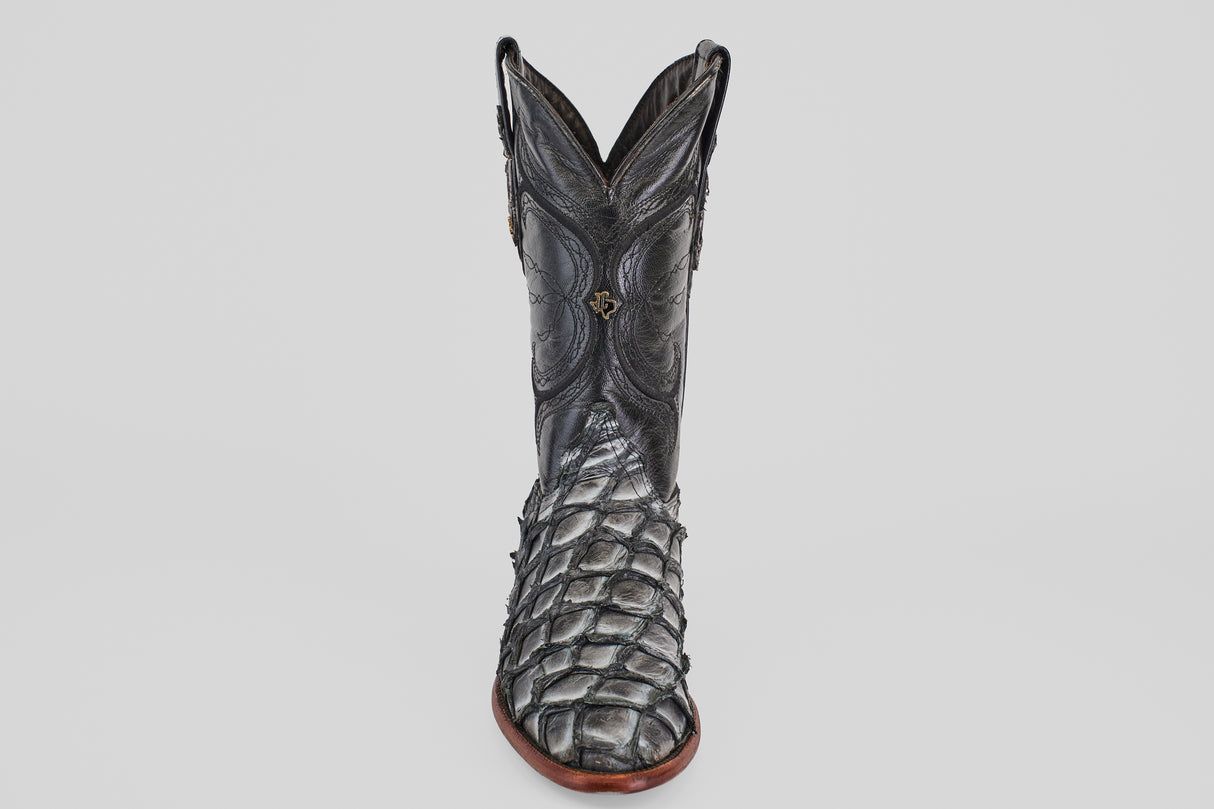 The Conor - Newspaper - Roper Toe boot features black exotic leather with a textured, scaly pirarucu-inspired pattern and intricate shaft stitching, displayed upright on a plain white background.