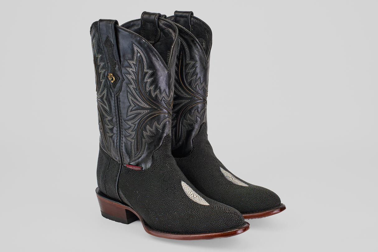 The Ranger – Black – Round Toe men’s cowboy boots feature black stingray leather with decorative stitching, a round toe, dark brown wooden heels and soles, and a distinctive white patch on the top of each foot.