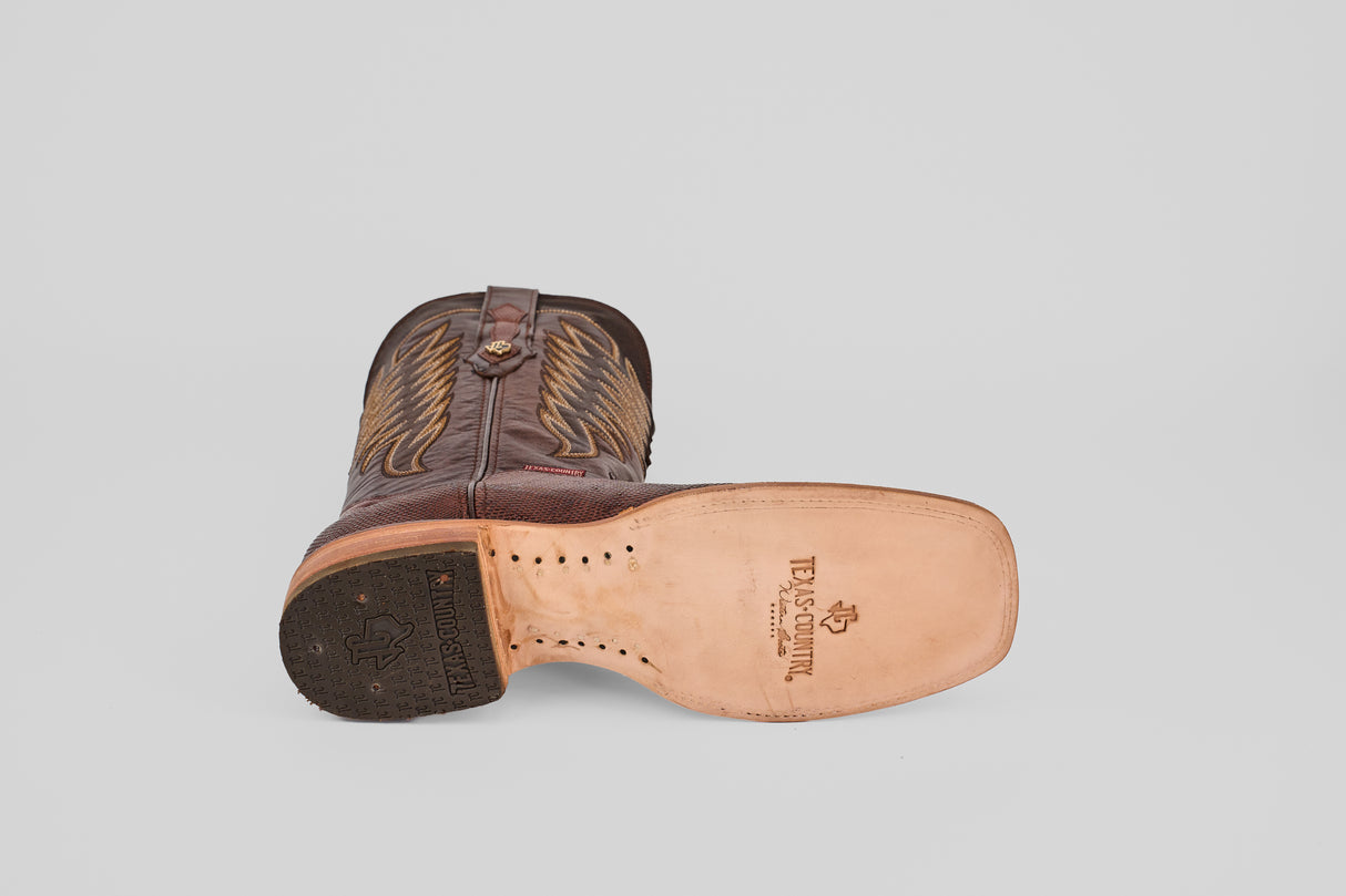 The Blaze – Brown – Square Toe Cowboy Boot is shown on its side, revealing a tan leather sole with branding, a partially black heel with logo imprint, and classic western-style decorative stitching.
