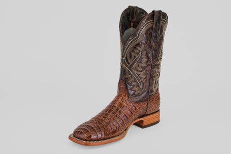 The Caiman Belly Choco - Embossed Leather - Square Toe (E423) cowboy boot showcases crocodile-embossed leather, decorative shaft stitching, a square toe, and a stacked wooden heel, displayed against a plain light background.