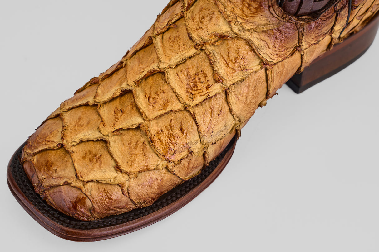 A close-up of the Conor Platinum - Buttercup - Square Toe (Herradura) boot shows textured, reptile-like leather, detailed stitching, and a wooden sole—an ideal standout western boot for men.