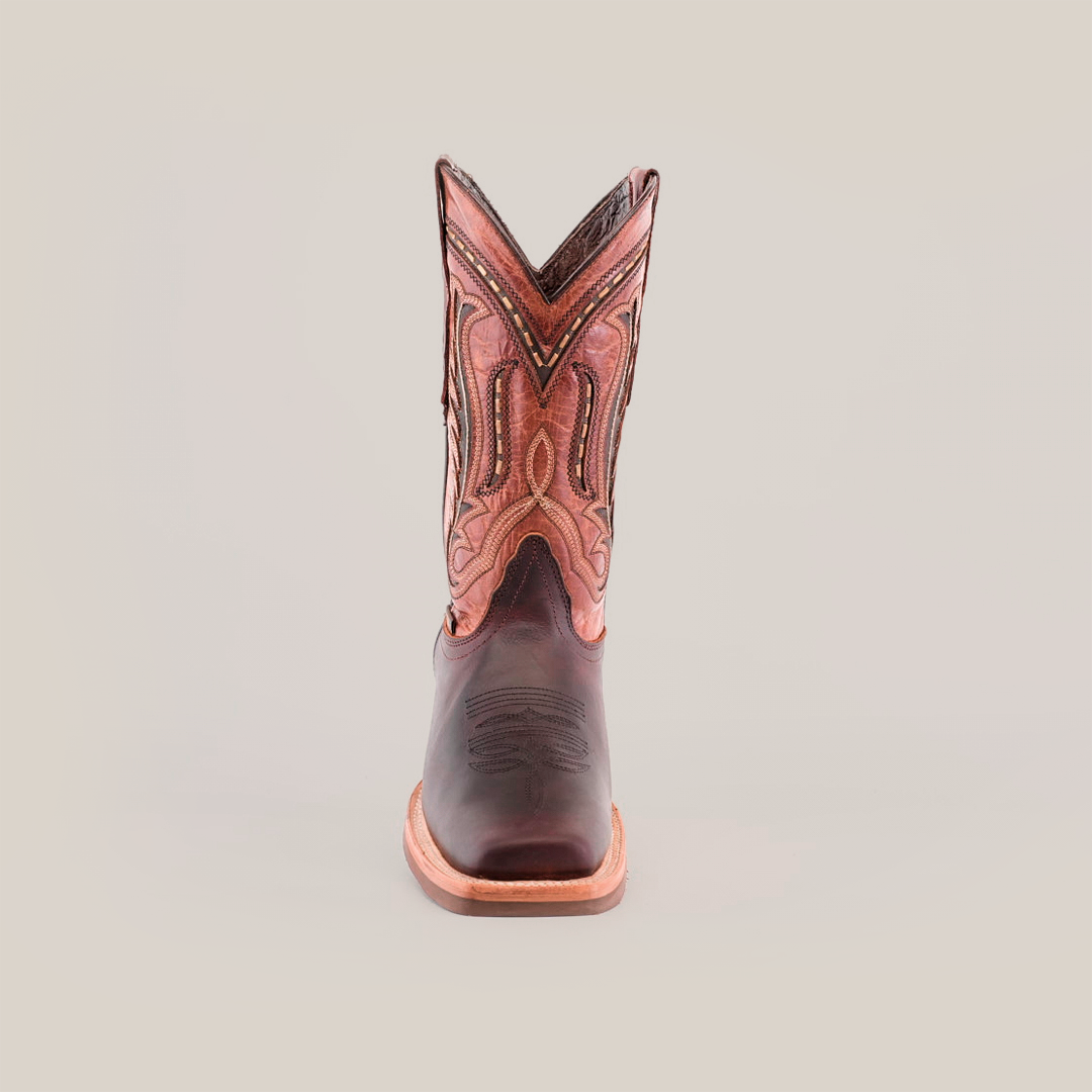 A top view of Azkar Moka boots reveals intricate stitching on the dark cowhide leather toe and an ornate design on the shaft. These boots, crafted from premium materials, feature a light brown slip-resistant sole with a visible seam around the edge.
