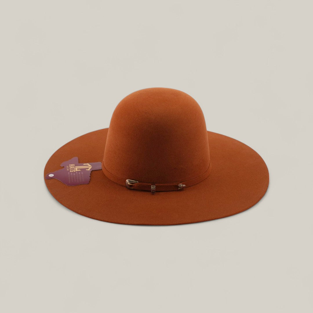 The 4x - Brick - TC Hats features a rust color, open crown, wide brim, rounded crown, decorative metal buckle, purple and gold side tag, and a stylish band, set against a plain beige background.