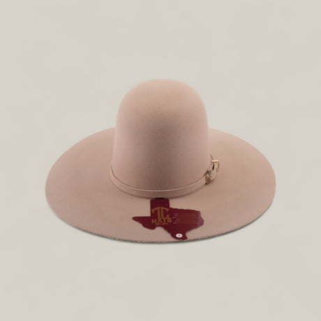 The 4X - Belly - TC Hats is a beige Western hat with a wide brim, shapeable crown, decorative band, and a dark red Texas outline with HALF 3 text and a star on the brim.