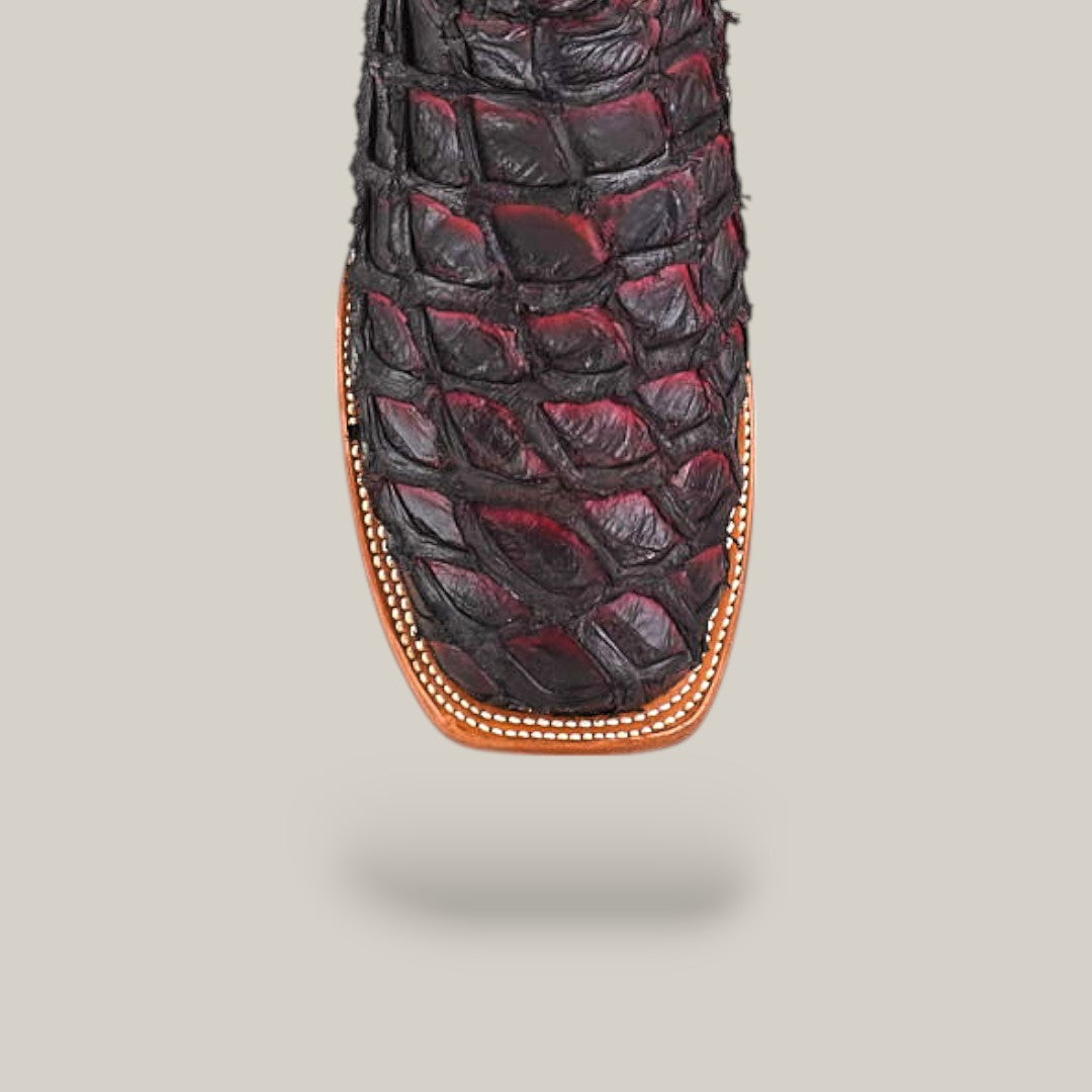 A close-up of the Maverick - Wild Cherry - Square Toe cowboy boot, showcasing its black and burgundy reptile-textured pattern and detailed stitching along the brown sole.