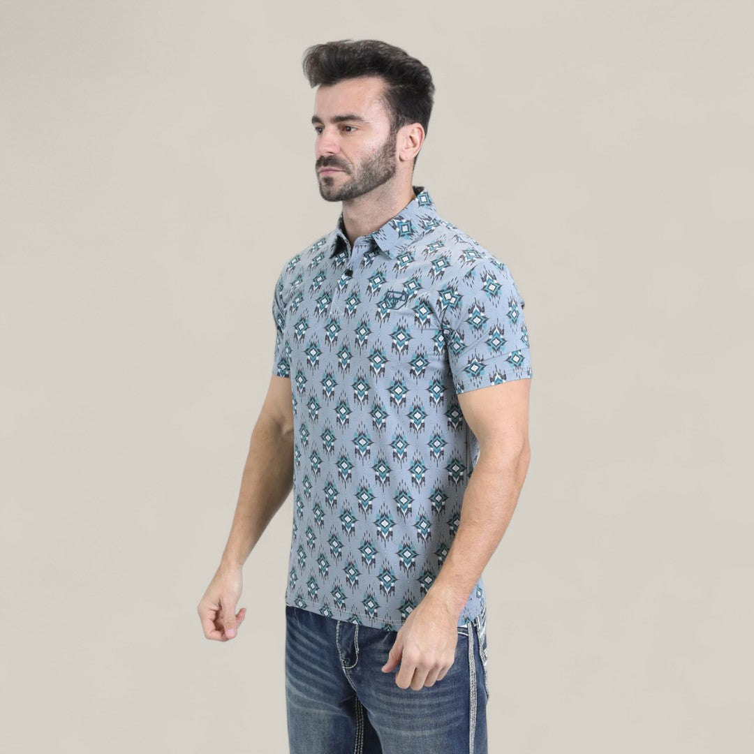 A man with short dark hair and a beard wears the Mens Performance Fabric Modern Fit Stretch Aztec Print Blue Polo (PGP10871) and blue jeans, standing against a plain light beige background.