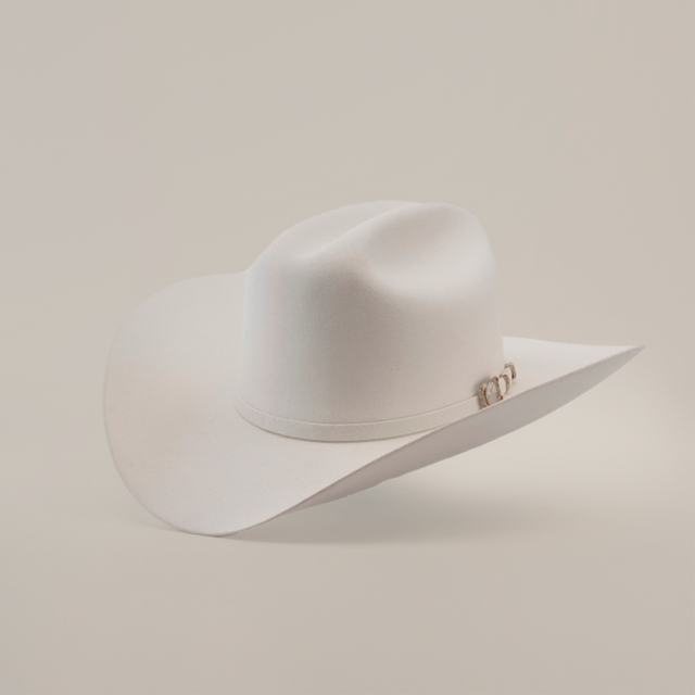The 100X Independecia White is a luxurious cowboy hat made from full beaver fur. Featuring a broad brim, a slightly creased crown, and small decorative detail on the side, it rests elegantly against a plain light background—a true emblem of premium western headwear.