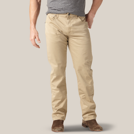A person wearing a gray t-shirt, beige pants, and brown suede shoes stands against a neutral background. Their left hand is by their side, and their right hand rests casually in the pocket of their Mens Wrangler Retro Slim Fit Straight Leg Pant - 1088MWZFN.