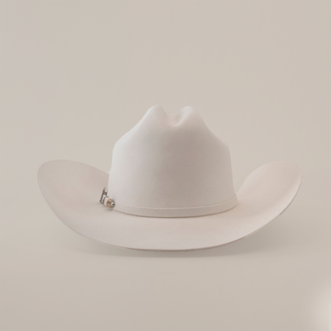 The 100X Independencia White is a luxurious cowboy hat made of full beaver fur, featuring a curved brim and a pin on the band, set against a plain light gray background.