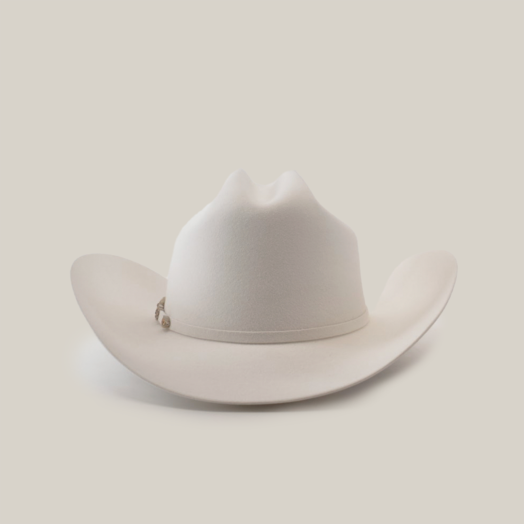 The 500X Superior White is a luxurious belly beaver fur cowboy hat with a slightly curved brim and distinct crown crease. Set on a plain white background, it boasts an elegant decorative band around the base of the crown.