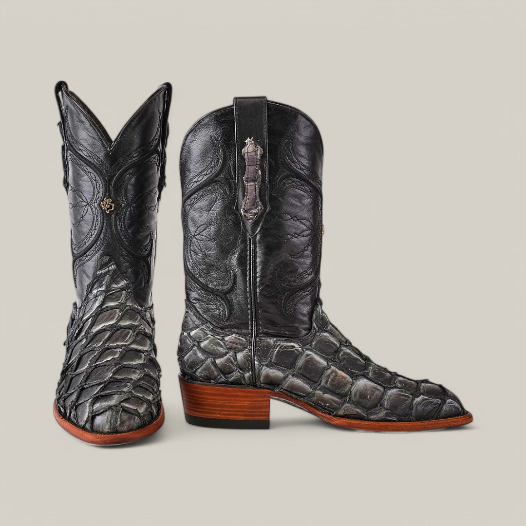 The Exotic Pirarucu Fish - Newspaper - Roper Toe cowboy boots feature intricate textured detailing with a scaly pattern reminiscent of Pirarucu fish leather on the toe and lower shaft, complemented by a wooden heel for rugged charm and sophisticated elegance that enhances any wardrobe.