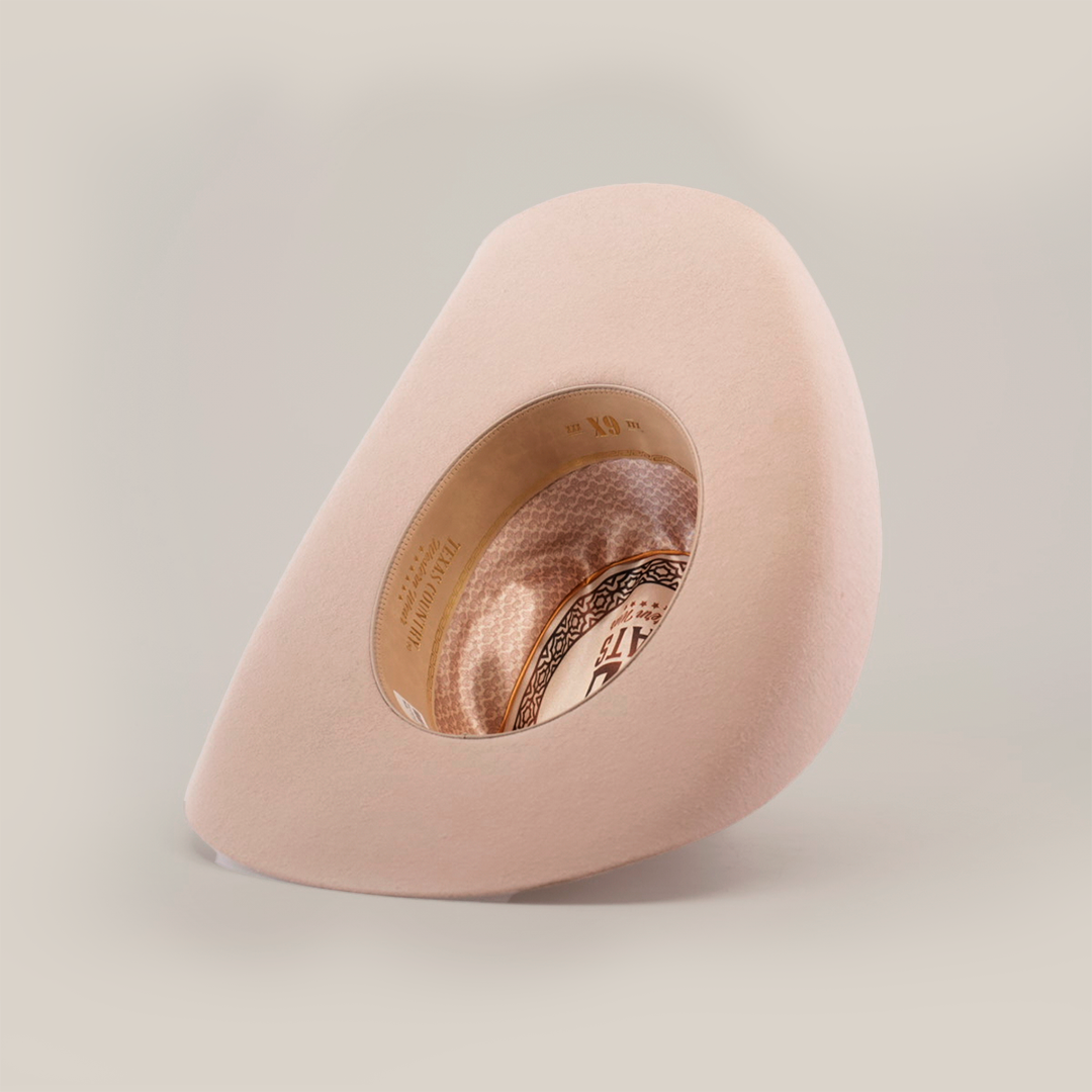The photo showcases the 6X Chihuahua Belly, a light beige cowboy hat made from premium sheep wool, displayed upside down to reveal its intricately patterned inner lining against a clean white background, highlighting the elegance of this classic cowboy piece.