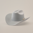The 6X Real Platinum by Larry Mahan is a light gray fur felt Western hat featuring a wide brim, crown crease, and a subtle decorative band with a small buckle, set against a plain white background.