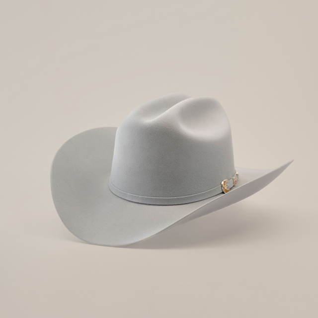 The 6X Real Platinum by Larry Mahan is a light gray fur felt Western hat featuring a wide brim, crown crease, and a subtle decorative band with a small buckle, set against a plain white background.