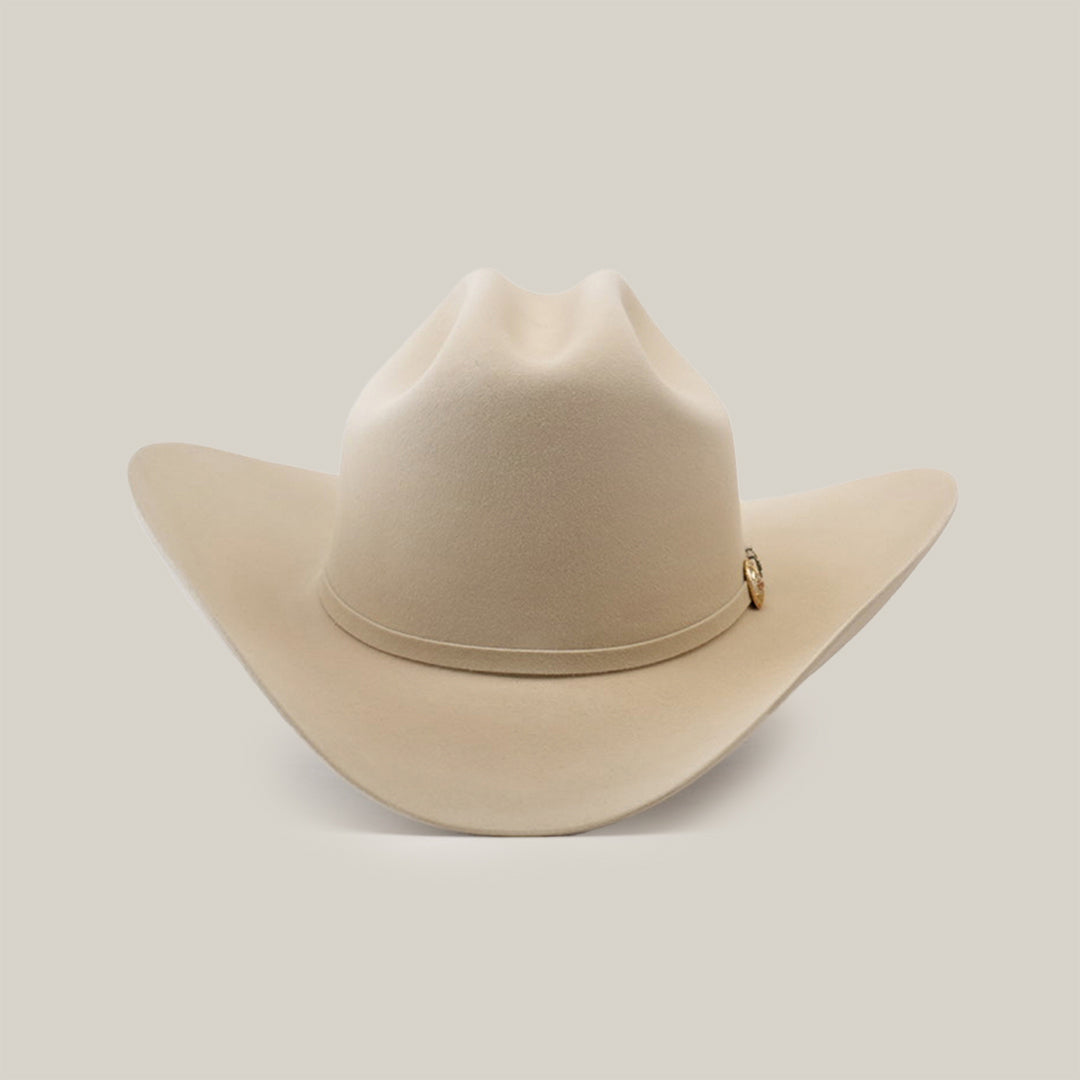 The 500X Superior Belly is a premium beige cowboy hat made from 100% belly beaver fur, featuring a wide brim and subtle top crease. Elegantly set against a plain white background, it boasts a small decorative emblem—truly exceptional Western headwear.