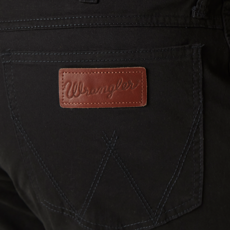 Close-up of Mens Wrangler Retro Slim Fit Straight Leg Pant - 88MWZBK in black, highlighting the back pocket with dark stitching and a brown leather patch embossed with Wrangler, showcasing their premium denim craftsmanship.