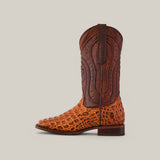 The Alligatoar Horn Back Print Honey features a textured orange alligator pattern on the foot, a brown upper shaft with decorative stitching, a pointed toe, and a low heel. It stands against a plain light gray background.