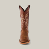 A single Siberia Honey cowboy boot, featuring intricate embroidery on the shaft, crafted from premium brown leather with a square toe, stands centered against a plain background.