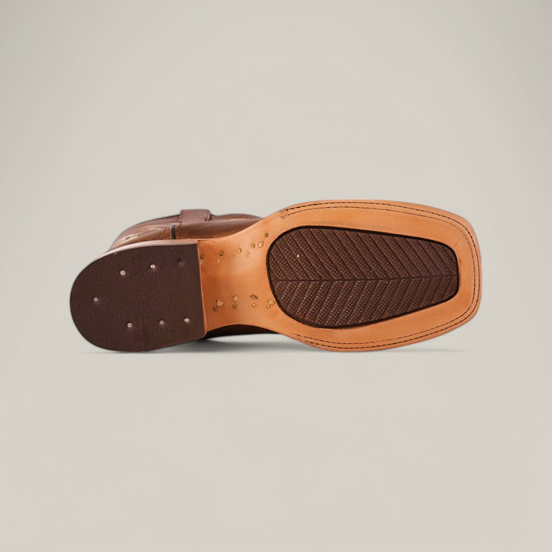 Bottom view of the Siberia Honey - Square Toe boot in premium leather, featuring a light tan sole with textured tread. The heel is dark brown, with small nails visible near the heel and arch, set against a plain light beige background.