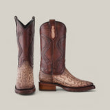 A pair of Exotic Carunga - Diamond - Natural boots, one upright and the other slightly tilted, highlights Western craftsmanship with a rich brown leather shaft, tan textured lower section with intricate stitching, and a sturdy medium-height heel.