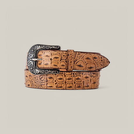 A tan Caiman Print Orix Belt with an ornate Texas buckle, featuring engraved detailing, is coiled neatly against a plain cream background.