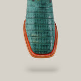 A top view showcases the Exotic Caiman Belly Tail boot in green with a square toe, featuring premium caiman leather. The tan leather sole with red trim and white stitching contrasts against a light gray backdrop, highlighting its exotic pattern.