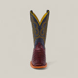 The Exotic Caiman Belly Tail boot in Wine features a square toe, brown crocodile-textured foot, dark upper shaft with intricate yellow stitching, showcased against a plain background for added flair.