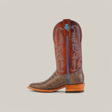 The Exotic Caiman Belly Tail - Gray - Square Toe boot boasts a textured crocodile pattern on the foot with intricate blue and white stitching on the shaft, featuring a blue emblem. It epitomizes Western style elegance with its wooden heel set against a plain light gray backdrop.