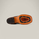 The image reveals the sole of an Exotic Caiman Belly Tail shoe, Gray with a Square Toe, featuring a unique Western-style pattern. The textured grooves, stylized logo initials, and contrasting tan and black colors highlight the refined craftsmanship typical of exotic leather designs.