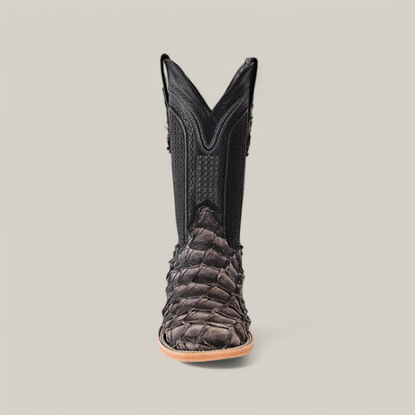 A single Exotic Pirarucu Fish boot with a square toe, made from dark, textured skin and smooth black leather with decorative stitching, rests on a light gray background, highlighting the stylish use of sustainable materials.